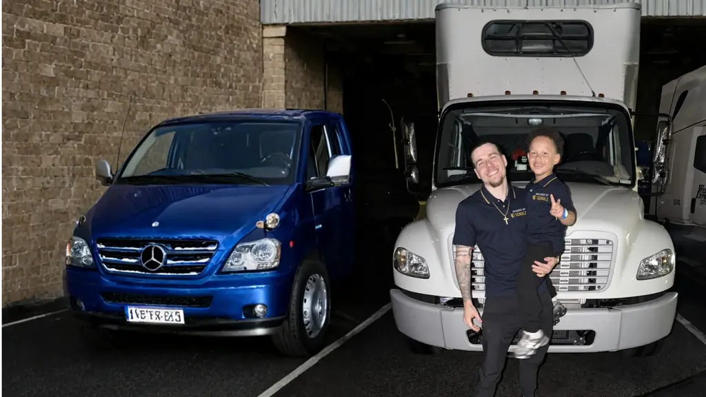 Anthony Schulz holding his son in front of his box truck
